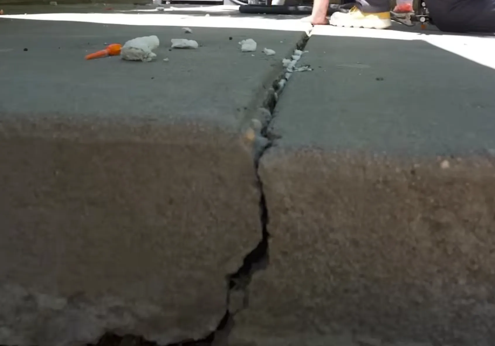 Before concrete leveling - sunken slab with visible settlement gap
